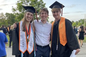 A photo of three people at a high school graduation ceremony